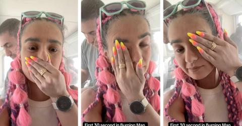 A TikTok user wipes dust from her face at Burning Man.