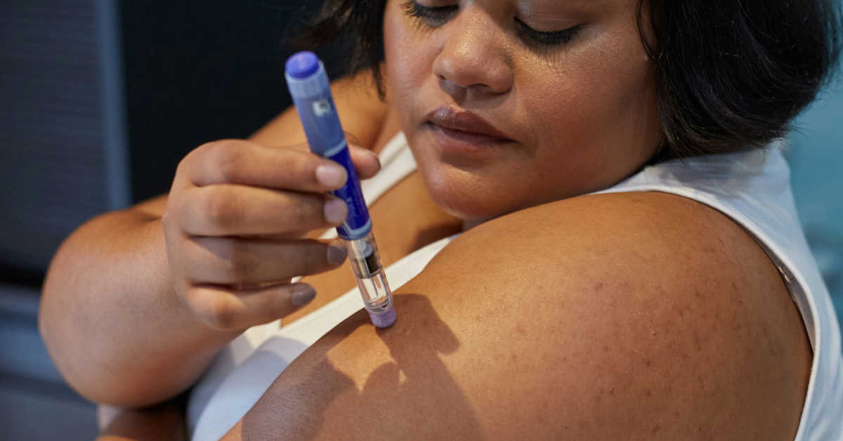 A woman gives herself a dose of Ozempic