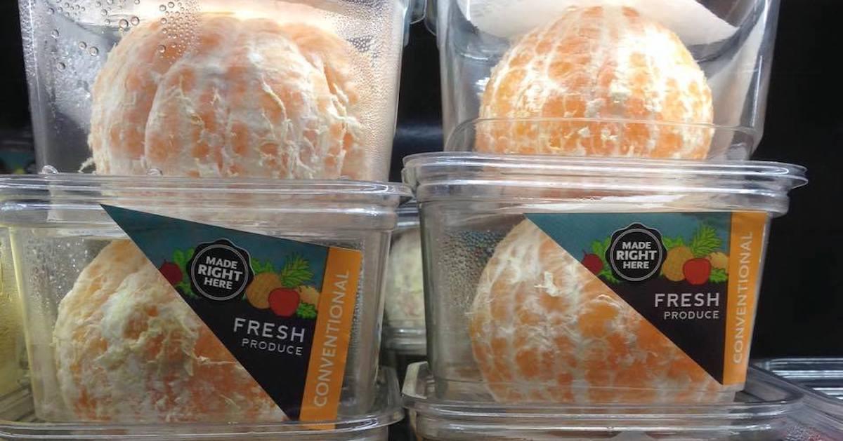 Four peeled oranges sit in their own plastic containers