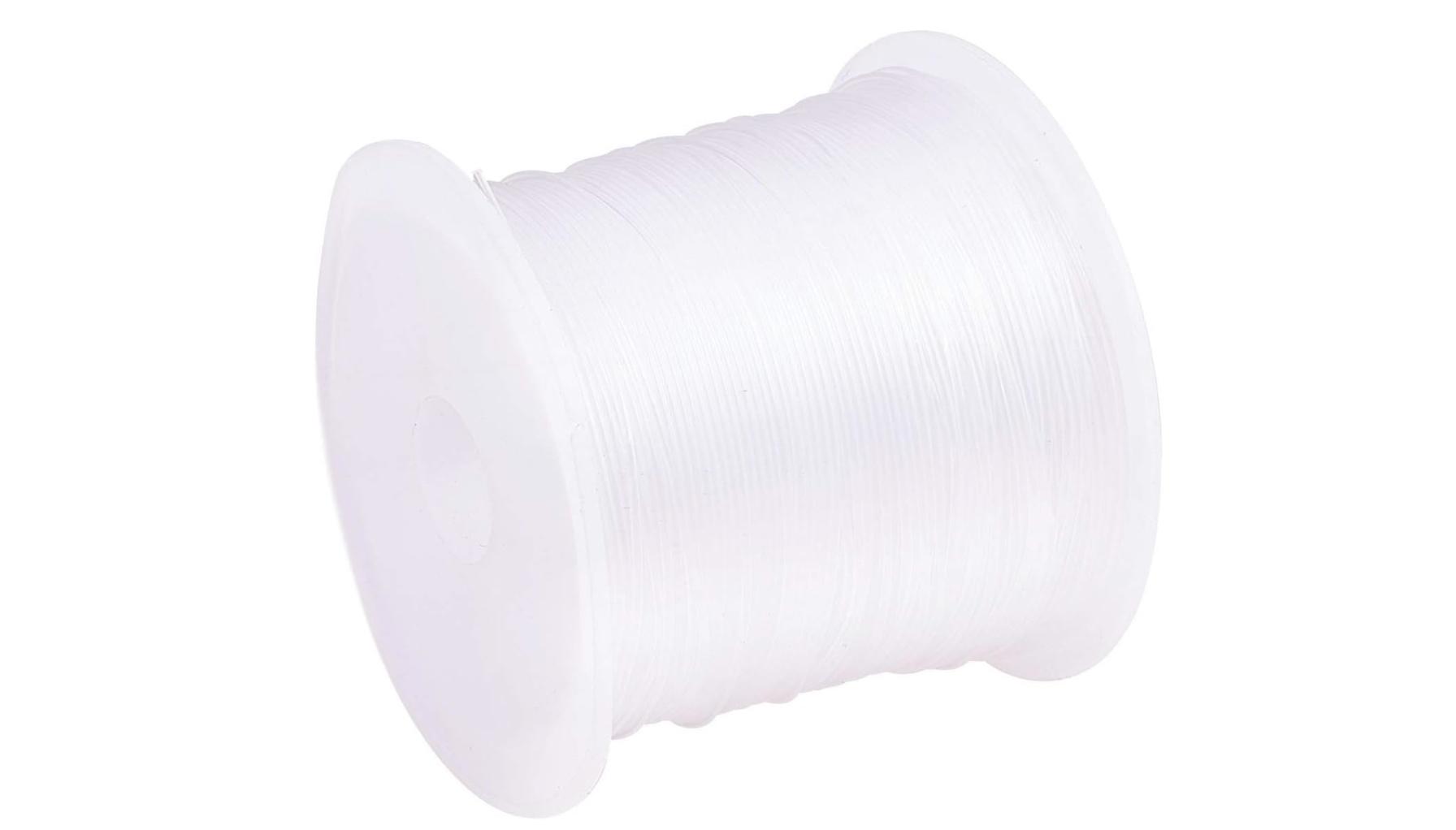 A spool of clear fishing wire against a white background.