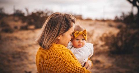A mom holding her baby girl in an arid desert. (Representative Cover Image Source: Getty Images | Cavan Images)