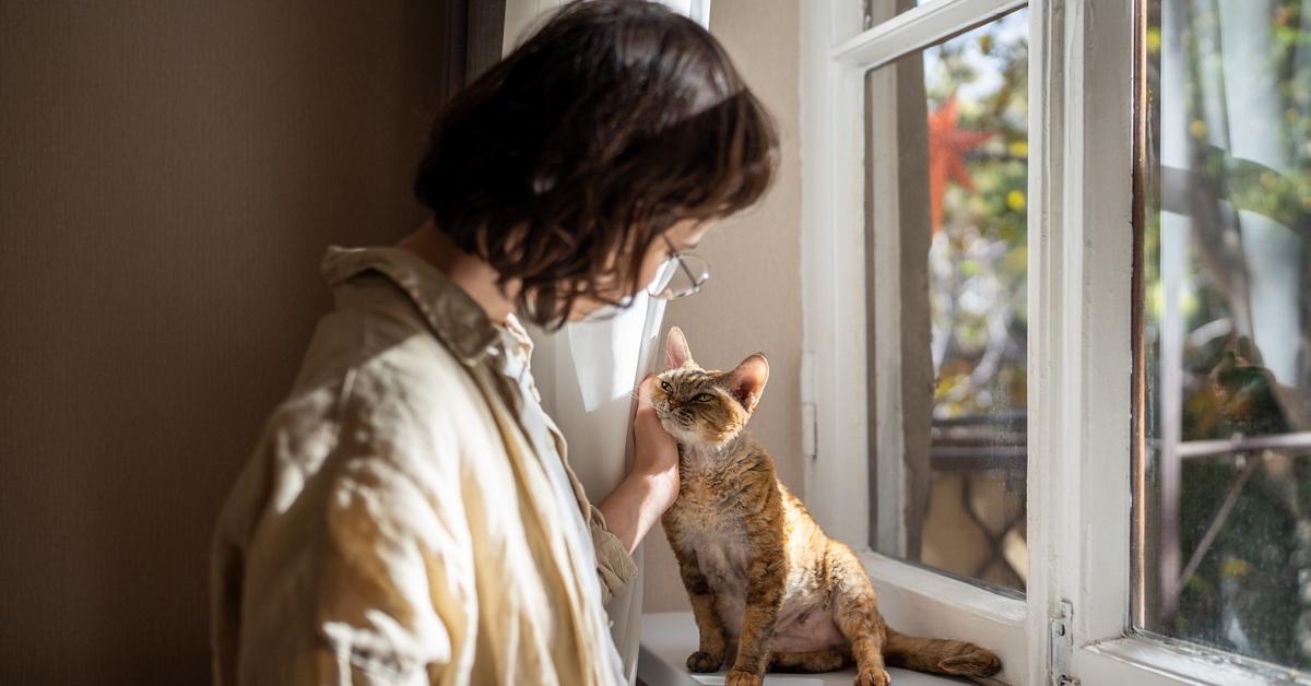 Woman petting an emotional support animal on her window. 