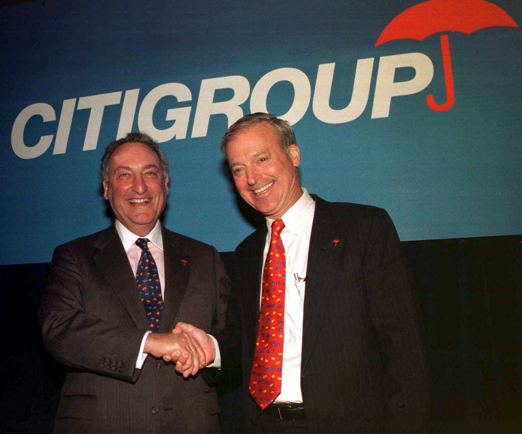 Travelers CEO Sanford Weill (left) and Citicorp CEO John Reed (right) at a 1998 press conference announcing the merger of their two companies.